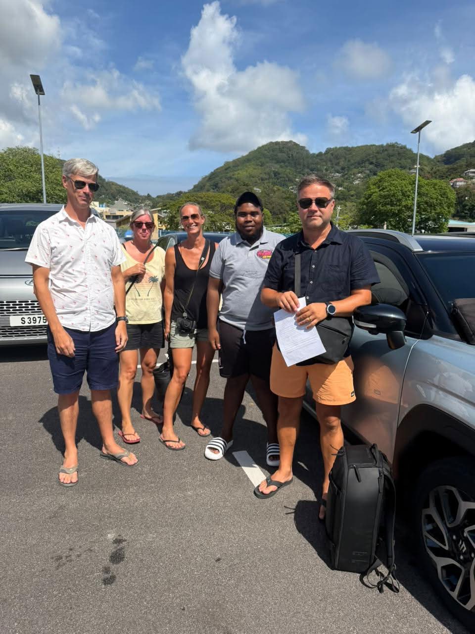 Visitors and a Sweet Car Hire team member beside a dark SUV